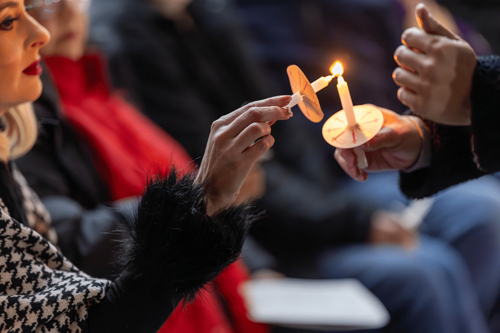 A woman lights a candle.