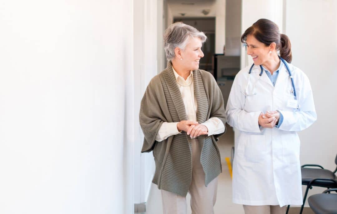 A healthcare provider and patient walk and talk.