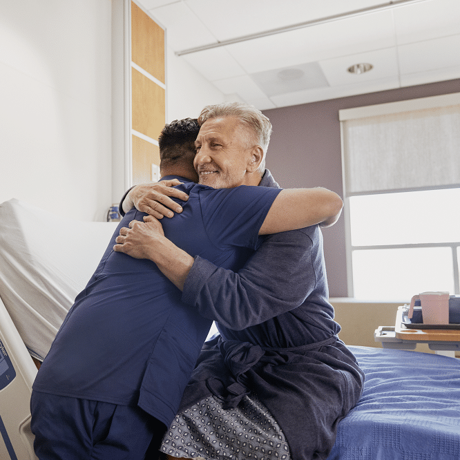 A patient hugs his caregiver.