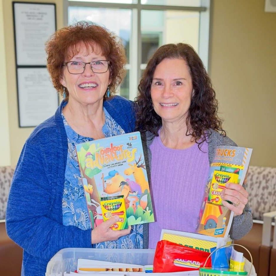 Debbie Cordero and Sharon Carvalho hold Alli's Inspiration coloring books.