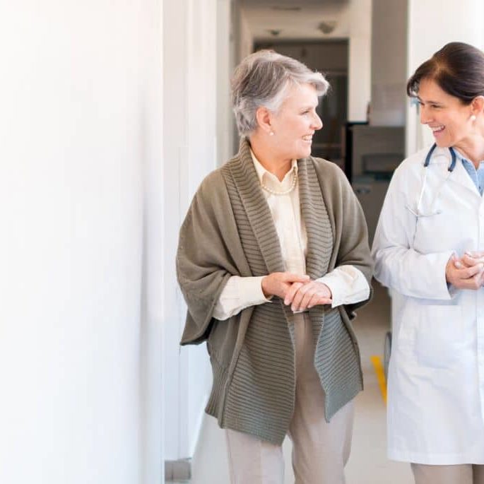 A healthcare provider and patient walk and talk.
